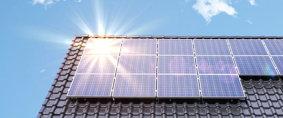 Solaranlage auf dem Dach eines Hauses im Sonnenlicht – Symbolbild für die Nutzung von Photovoltaik zur Senkung der Energiekosten inklusive staatlicher Fördermöglichkeiten für erneuerbare Energien.