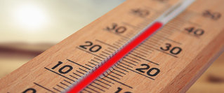 Nahaufnahme eines Thermometers mit hoher Temperaturanzeige – Symbolbild für eine Hitzewelle, mögliche Hitzeschäden und den passenden Versicherungsschutz bei extremen Temperaturen.