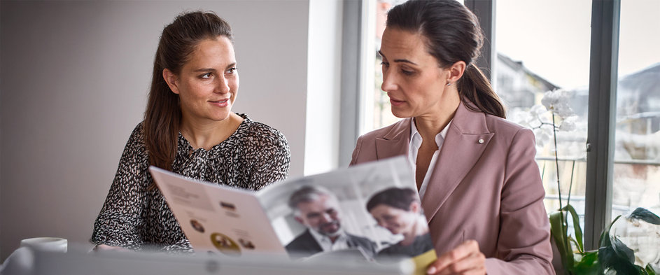 Finanzcoach der DVAG erklärt einer Kundin eine Informationsbroschüre – persönliche Beratung zur Altersvorsorge und zu möglichen Reformen der Riester-Rente.